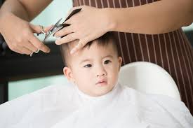 baby boy cutting hair by his mom