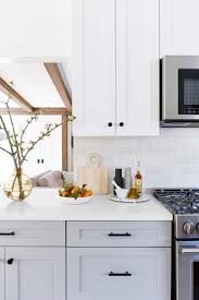 Clean white kitchen cabinets with black hardware in a minimalist kitchen. White Kitchen Cabinets With Black Hardware Decorkeun