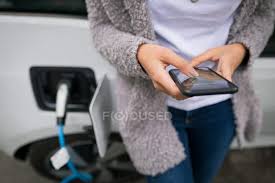 But using your phone while you are charging it can be hazardous. Close Up Of Woman Using Mobile Phone While Charging Electric Car At Charging Station Transport Regenerative Stock Photo 212450784