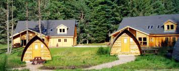 Open plan living accommodation with double bed, fitted kitchen and sitting area with woodburning stove. Chalets Lodges Visit Aviemore