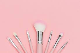 set of pink makeup brushes on pastel