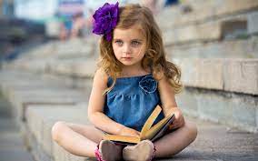 Cute little girl reading a book ...