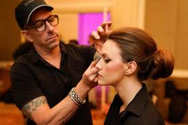 makeup artist carl ray providing touch ups to a model