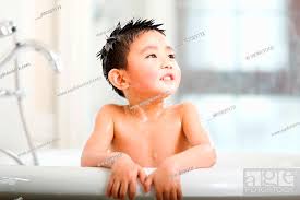 the cute little boy is taking a bath