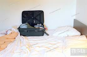 open suitcase on bed in hotel room