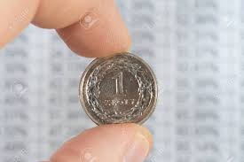 A Man Holds A Polish Zloty Pln Coin In Front Of A Chart