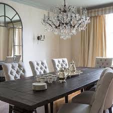 A small dining space with a wooden dining table paired with black chairs over concrete flooring. Dark Wood Dining Table With Gray French Dining Chairs French Dining Room Dark Wood Dining Table Wood Dining Room Dining Room French