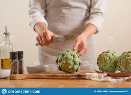 Chef Cooks Artichoke On A Light Background Concept Cooking