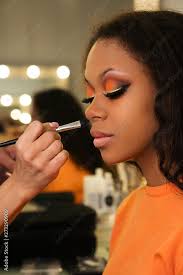 makeup artist applies foundation for