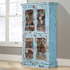 It's made from solid and engineered wood and has two mirrored doors that open to reveal an array of adjustable shelves. Bancroft Distress Blue Rustic Solid Wood Tall Storage Cabinet Armoire