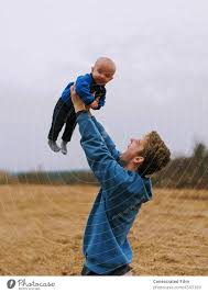 man lifting up baby in the air with joy