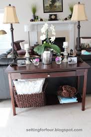 This image is another example of how to decorate around a dark sofa, even if it's not leather. How To Style A Sofa Table And Define Your Living Room Setting For Four
