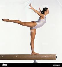 young female gymnast on balance beam