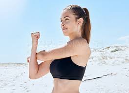 woman stretching arm and beach fitness
