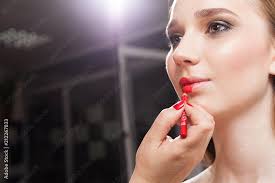 makeup artist applying red lipstick on
