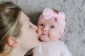 daughter mom kisses little baby
