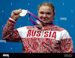 La medallista rusa Tatiana Kashirina sonríe en el podio durante la  ceremonia de la victoria para la competición de pesas de +75 kg en la sede  de Excel durante los Juegos Olímpicos