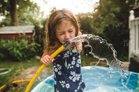 Girl Drinking Water From A Garden Hose