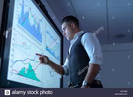 Businessman Viewing Charts And Graphs On Interactive Screen