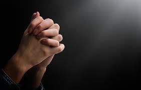 photo praying hands on a dark background