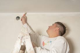 Young Male Painter Using A Brush To