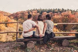 3人の若い美しい人々が木製のベンチに座り、秋の風景、愛の三角形と裏切りの概念を楽しむ の写真素材・画像素材. Image 97665730.