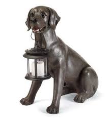 black labrador dog statue holding a
