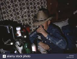 young boy wearing a cowboy hat drinks a