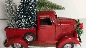 Front of truck decorated with holly leaves. 12 Nostalgic Red Christmas Trucks For Your Holiday Decor