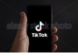 The logo of the media app tiktok features the letter d styled as a music note. Tiktok App Icon On The Smartphone Screen With Visible Pixels And The Finger About To Launch It Stock Photo Alamy
