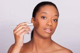 beautiful african woman applying makeup