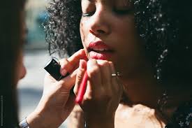 makeup artist applying red lipstick