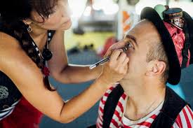 artist applying eyeliner to male artist