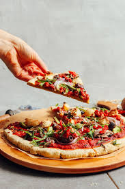 grabbing a slice of pizza created using our gluten free pizza crust recipe