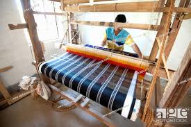 man weaving coloured silk sari on
