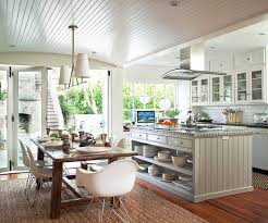 Gourmet kitchen boasts ceiling dotted with white industrial pendants illuminating island with beadboard trim topped with honed black countertops across from farmhouse sink flanked by beadboard trimmed dishwashers under window dressed in bamboo roman shade. Beadboard Ceiling Better Homes Gardens