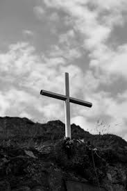 grayscale photo of a cross on a grave
