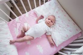 Two Week Old Baby Girl Sleeping In Her Crib On Pink Sheets With Cloud Pattern Top Down Shot Natural Light Buy This Stock Photo And Explore Similar Images At Adobe Stock