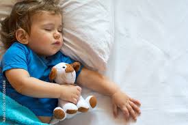 cute baby boy sleeping on the bed at