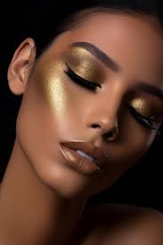 a woman with a gold makeup on her face