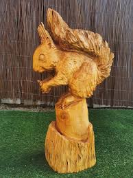 red squirrel eating carved wood garden