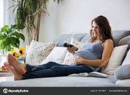 young pretty pregnant woman watching tv