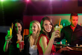 Woman drinking drink in front of nightclub bar Stock Photo free download
