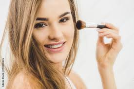 smiling beautiful woman applying makeup