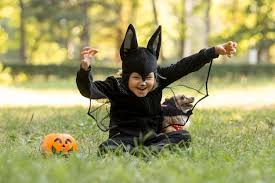 long shot of little boy in bat costume
