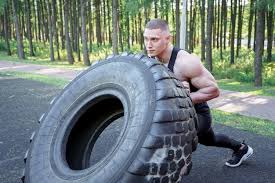 strong young man flipping tyre