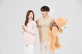 korean couple hugs teddy bear for