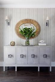 gold oval mirror over gray credenza