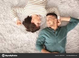 happy young couple lying carpet