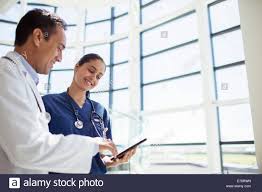 Doctor And Nurse Reading Medical Chart In Hospital Stock